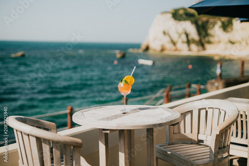 Foto Refreshing cocktail on a seaside terrace overlooking turquoise waters