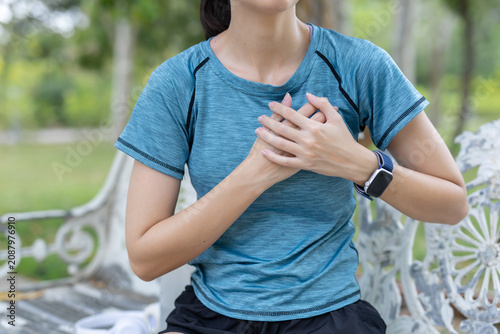Fotografi Female woman sitting park bench experiencing severe chest pain and distress duri
