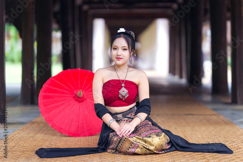 Beautiful Asian Woman in Traditional Lanna Costume at Wat Ton Kwen Ancient Wooden Temple, Chiang Mai, Thailand