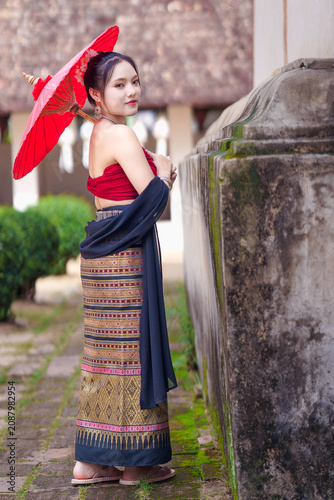 Beautiful Asian Woman in Traditional Lanna Costume at Wat Ton Kwen Ancient Wooden Temple, Chiang Mai, Thailand