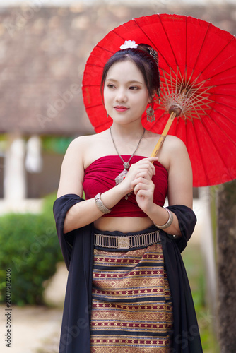 Beautiful Asian Woman in Traditional Lanna Costume at Wat Ton Kwen Ancient Wooden Temple, Chiang Mai, Thailand