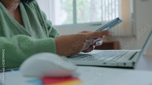 Asian woman using smartphone at home, working at home