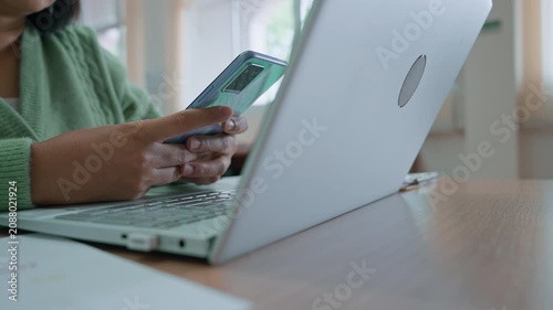 Asian woman using smartphone at home, working at home