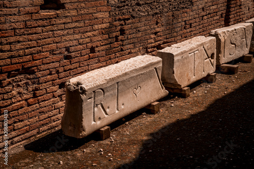 Canvastavla Sunlit ancient stone sarcophagi and carved marble blocks leaning against a weath