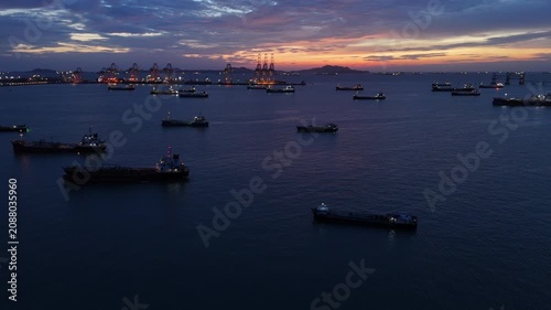  heavy oil tankers and LNG vessels anchored at a strategic maritime chokepoint during a golden sunset, emphasizing global energy crises and petroleum supply chain infrastructure.