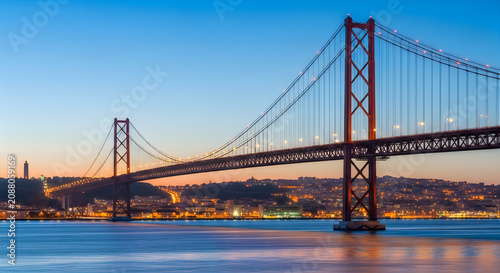 Modern suspension bridge over a city at sunset