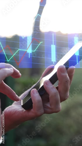 Investor checking stock market data on a mobile phone, analyzing financial charts and candlestick graphs for investment decisions, engaging in online day trading outdoors