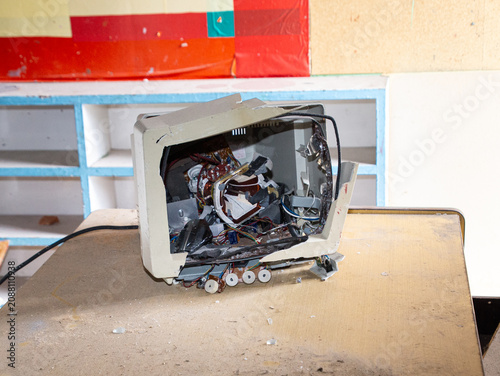 Fotografija Destroyed old crt monitor on a dirty wooden table, representing technology obsol