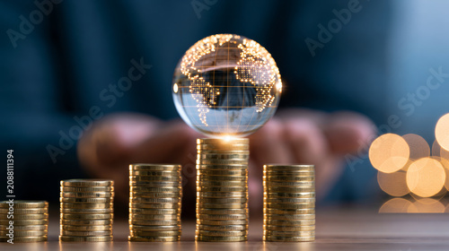 Business growth intelligence for 2027 is symbolized by stacked gold coins and glass globe, reflecting financial success, global strategy and optimistic economic outlook