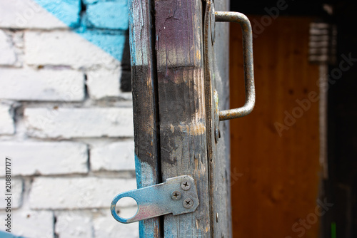 Foto Weathered wooden door post with rusty latch and hasp lock hardware
