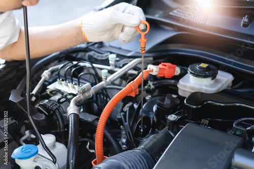 Quadro su tela Auto technician performing routine maintenance check on a hybrid car engine