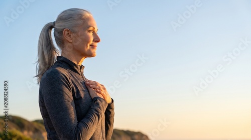 Mature Woman Practicing Deep Breathing and Mindfulness Outdoors at Sunset