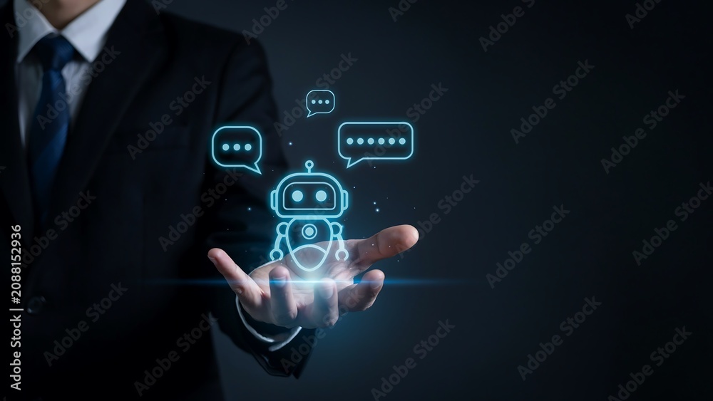 Fototapeta premium AI Assistant in Hand: A businessman in a suit holds a glowing chatbot icon in his palm, symbolizing artificial intelligence and modern digital assistance.
