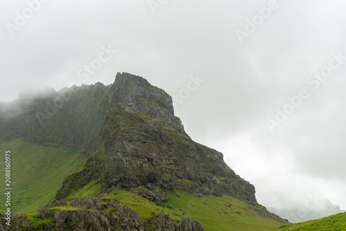 Cuadro en lienzo Rocky green mountain peak shrouded in low cloud and mist, Iceland