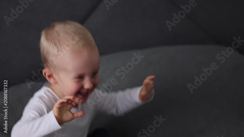 Happy smiling blonde child is having fun jumping on a bed. 4K