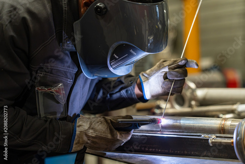 Obraz na plátně Welder in mask tig welding with sparks