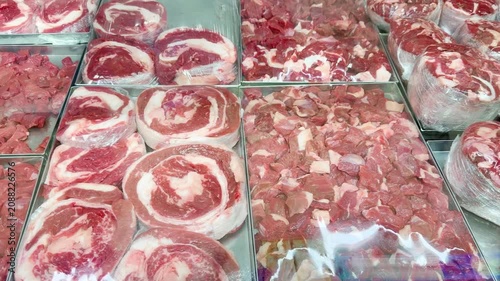 Fresh Meat Display at a Grocery Store Counter.Glass-Topped Refrigerated Meat Counter with Various Cuts of Meat in a Supermarket
