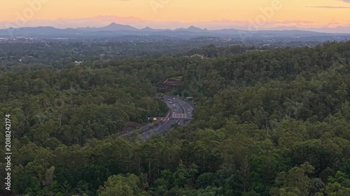 Aerial View of Forested Brisbane Suburbs and Winding Highway at Dusk