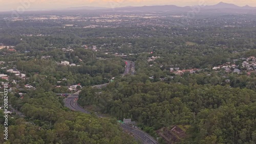 Aerial View of Forested Brisbane Suburbs and Winding Highway at Dusk