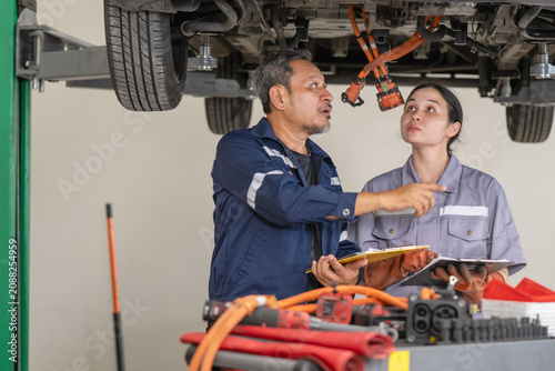 Obraz na plátně Team of mechanics working together to service and maintain an electric vehicle i