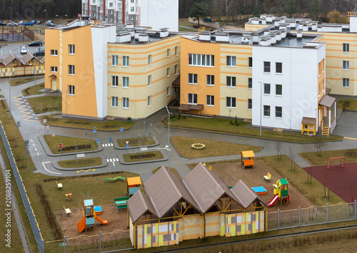 Modern school campus with colorful playground and sports area. Aerial View
