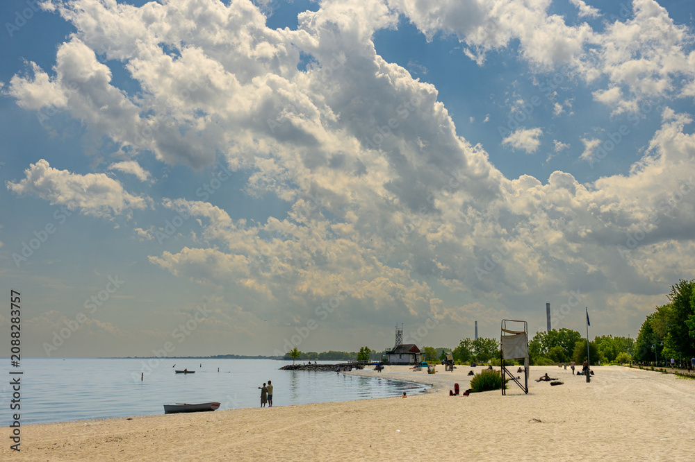 Obraz premium Beachgoers under dramatic summer storm clouds