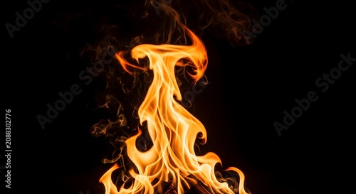 Bright burning fire flames rising against dark black background conceptual imagery