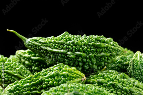 Pile of fresh bitter melons on black background.