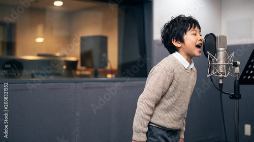 プロの音楽スタジオで感情を込めて熱唱する元気な男児 | 躍動感