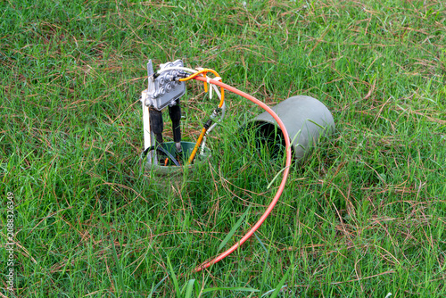 Fotografie Outdoor utility connection box for cable TV and internet services, showing various wires and conduits in green grass, representing essential telecommunications infrastructure