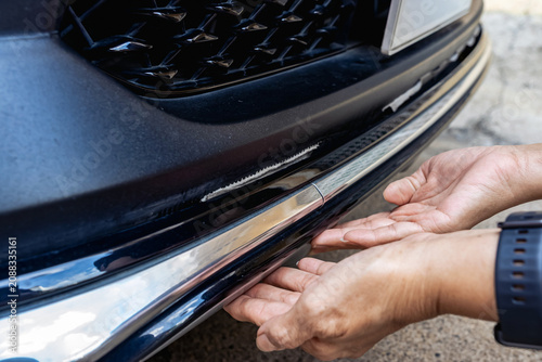 Quadro su tela Car owner check damaged front bumper skirt with hands