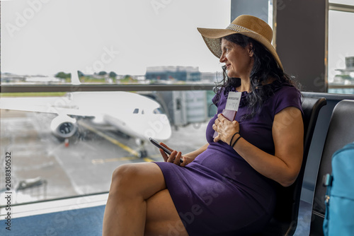 Fotografie Woman holding passport, anticipating travel journey at airport