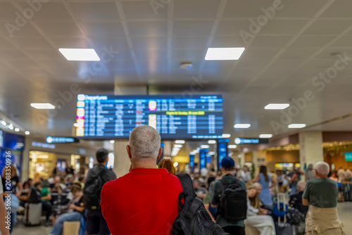 Traveler looking at airport departure arrival board