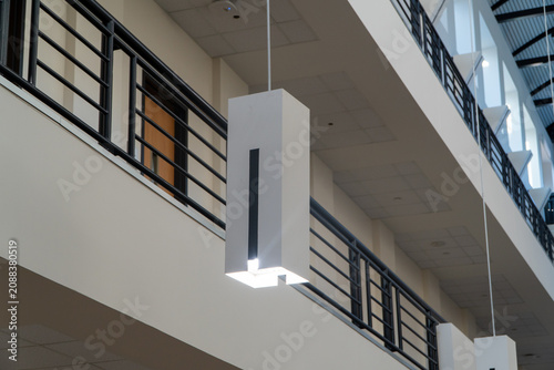Foto Modern minimalist pendant light fixture illuminates a spacious contemporary interior with architectural black metal railings and multi-level design, showcasing clean lines and bright spaces