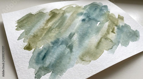 Abstract watercolor brush stroke pattern with organic green and blue washes on textured paper