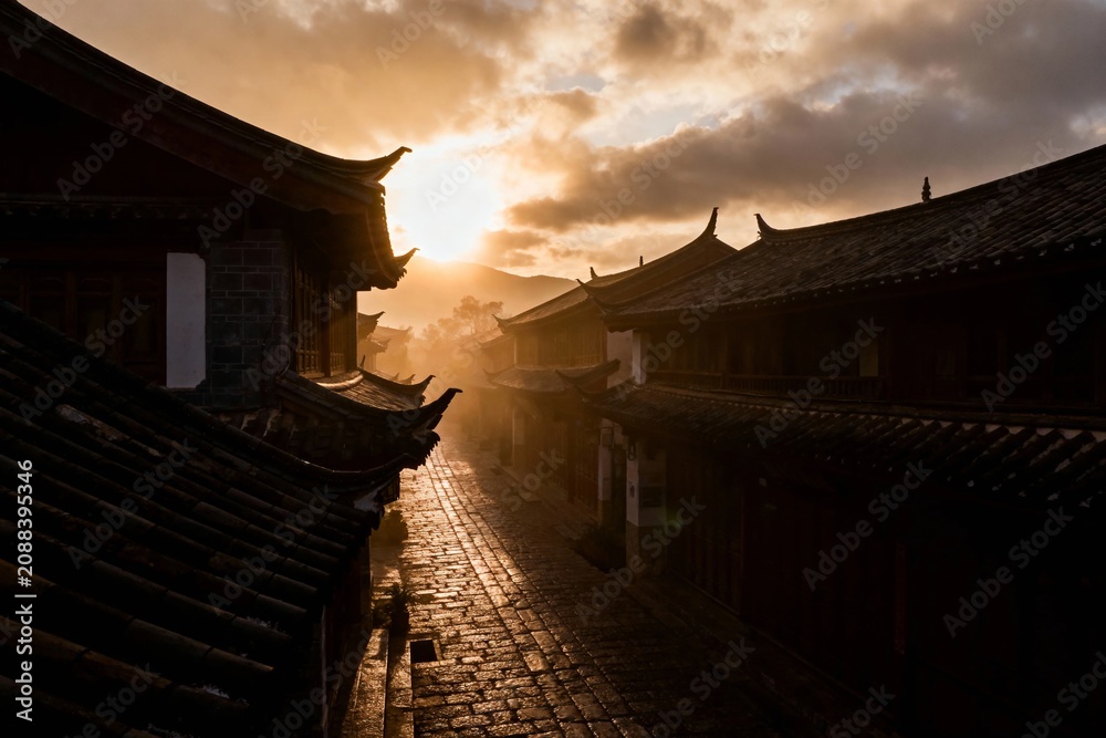 Obraz premium Sunset over traditional tiled rooftops in a historic alleyway