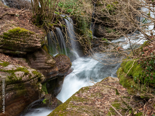 Beautiful waterfall cascading over mossy rocks in a lush spring forest