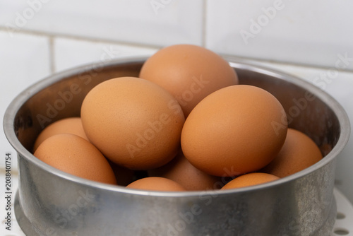 Fresh brown chicken eggs in stainless steel bowl