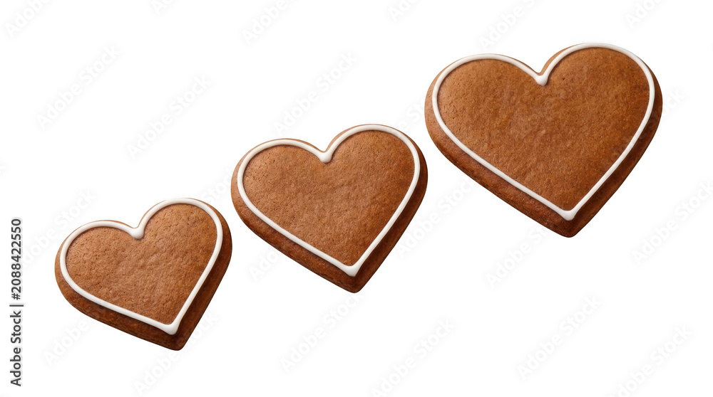 Obraz premium Three heartshaped gingerbread cookies with white icing isolated on transparent background