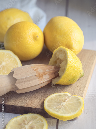 Fotografía lemons squeezed with a wooden reamer on a wooden board
