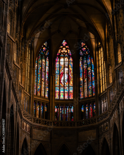 Billede på lærred Beautiful interior view of illuminated stained glass windows inside a historic Gothic cathedral