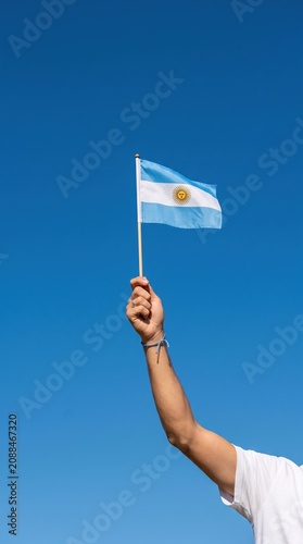 hand holding Argentina flag on nature background. 9th July of Independence day, 25th May of Revolution day and happy celebration concepts