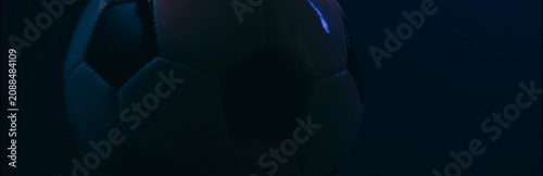 Rotating soccer ball close up on dark blue background