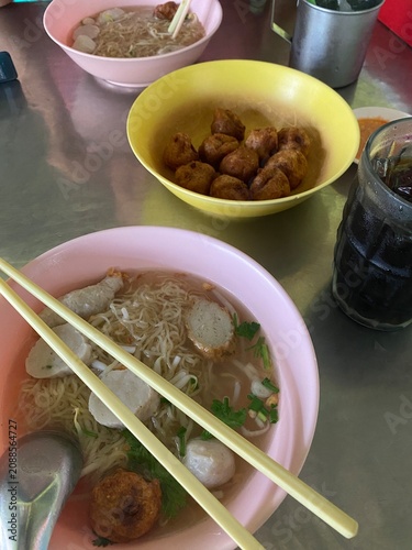 noodle soup. Thai noodle soup. Thai food. Asian food. Braised beef. Frish meatballs. Noodles. Hot broth. Chopsticks. Homemade food. Bowl of noodles. Comfort food.