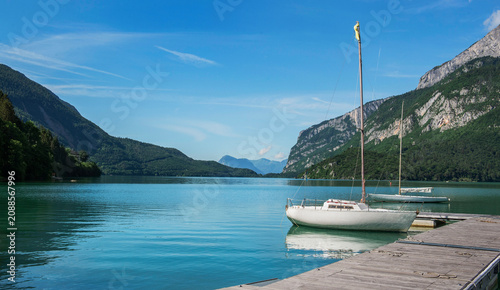 Cuadro en lienzo pleasure boat moored to a pontoon on a lake in the Dolomites with mountain backg