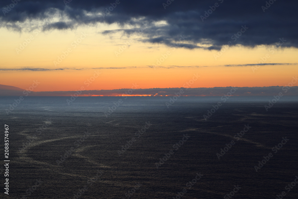 Fototapeta premium Dramatic sunset over the Atlantic Ocean beneath massive storm clouds