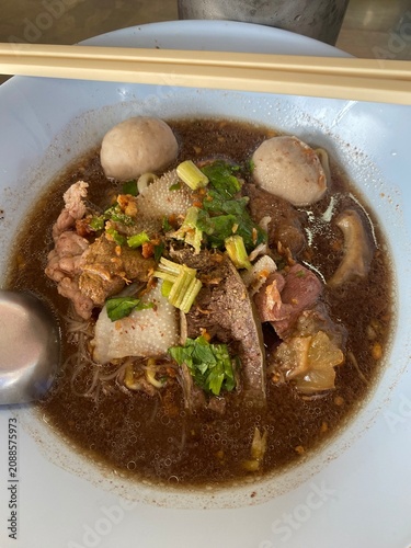 Beef noodle soup. Thai noodle soup. Thai food. Asian food. Braised beef. Beef meatballs. Noodles. Hot broth. Chopsticks. Homemade food. Bowl of noodles. Comfort food.