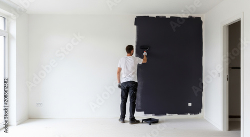 Man Painting Dark Accent Wall In Bright Modern Room Home Renovation Before After Contrast