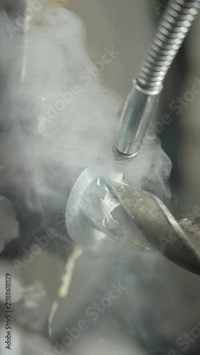 A metal part is being cut on a machine. Metalworking concept.