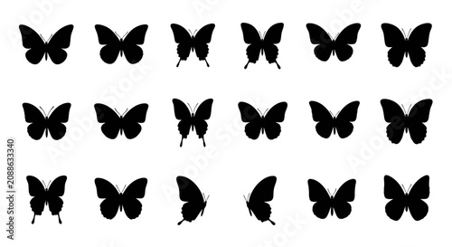 A collection of black butterflies are flying in formation on a plain background.